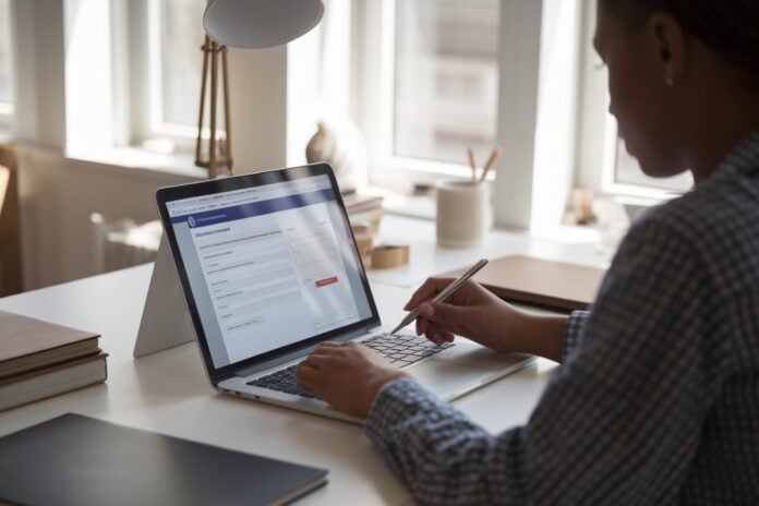 Person Filling Form on Laptop Personne remplissant un formulaire sur ordinateur portable