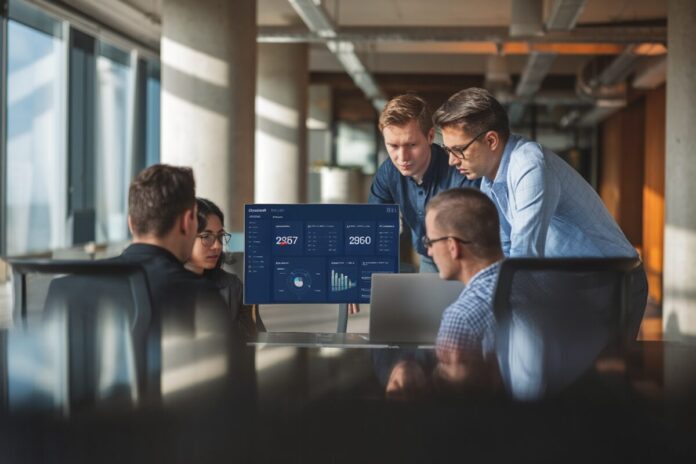 Équipe d’une start-up suisse présentant un tableau de bord d’IA