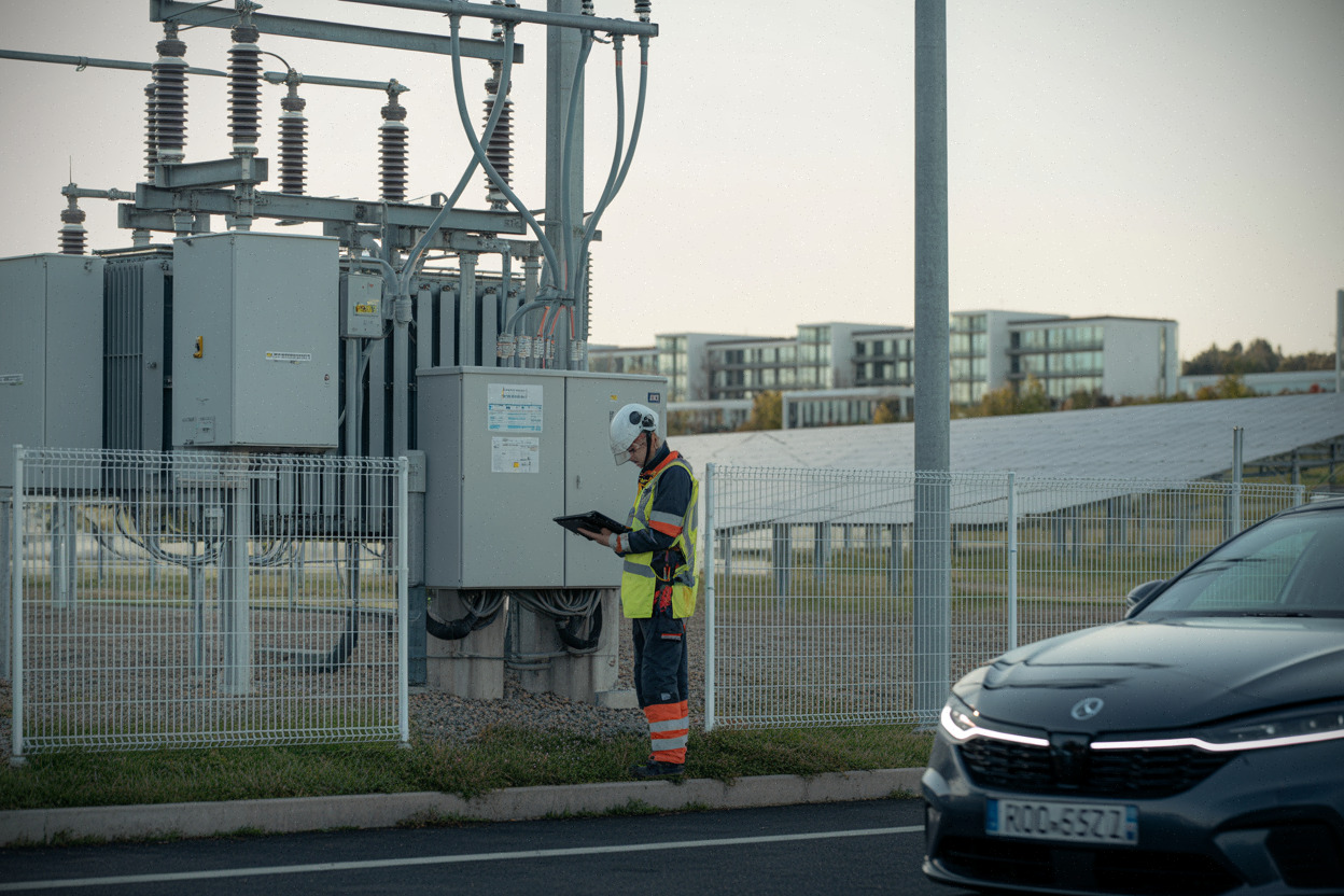 Poste électrique et raccordement près d’un parc solaire, techniciens au travail